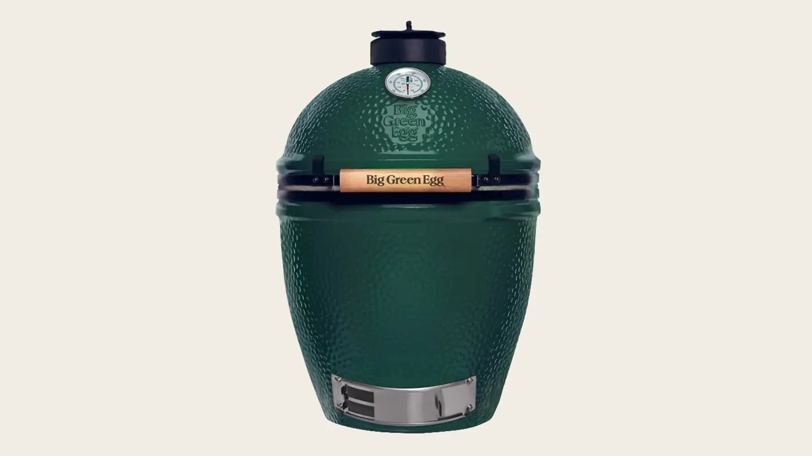 Big Green Egg Large de cerámica verde en una terraza, con la cúpula abierta y las brasas encendidas listas para asar