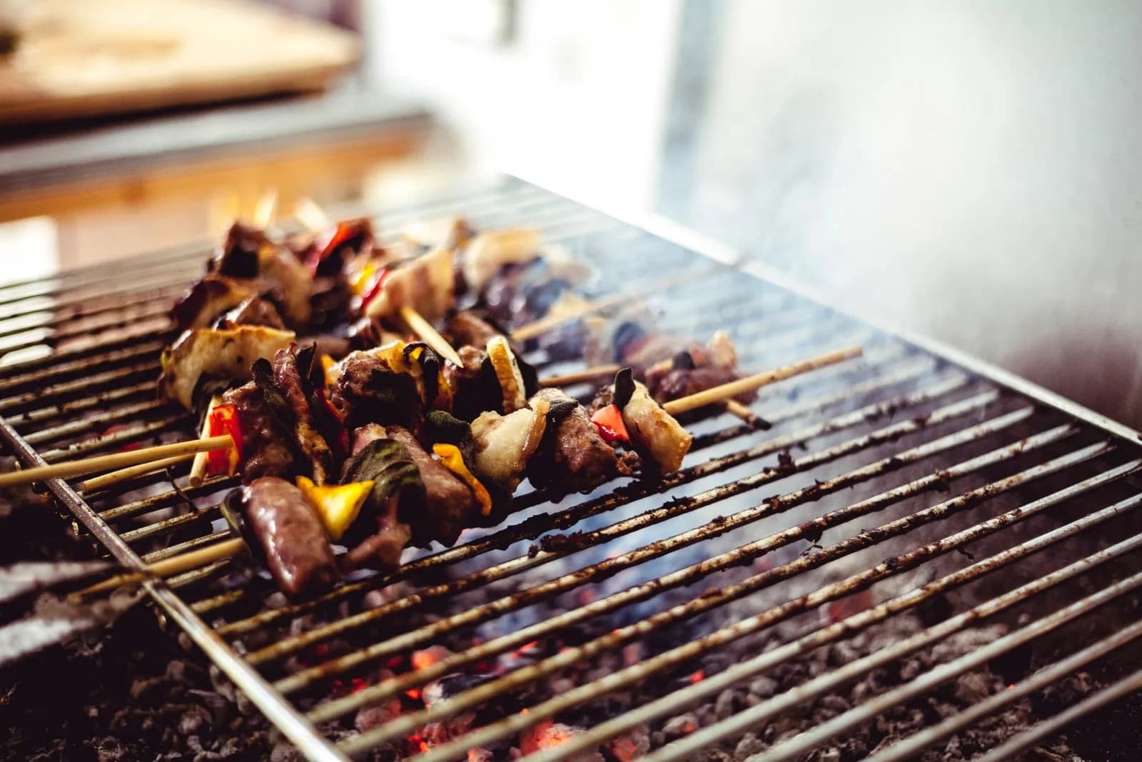 Brochetas a la brasa sobre carbón con humo elevándose