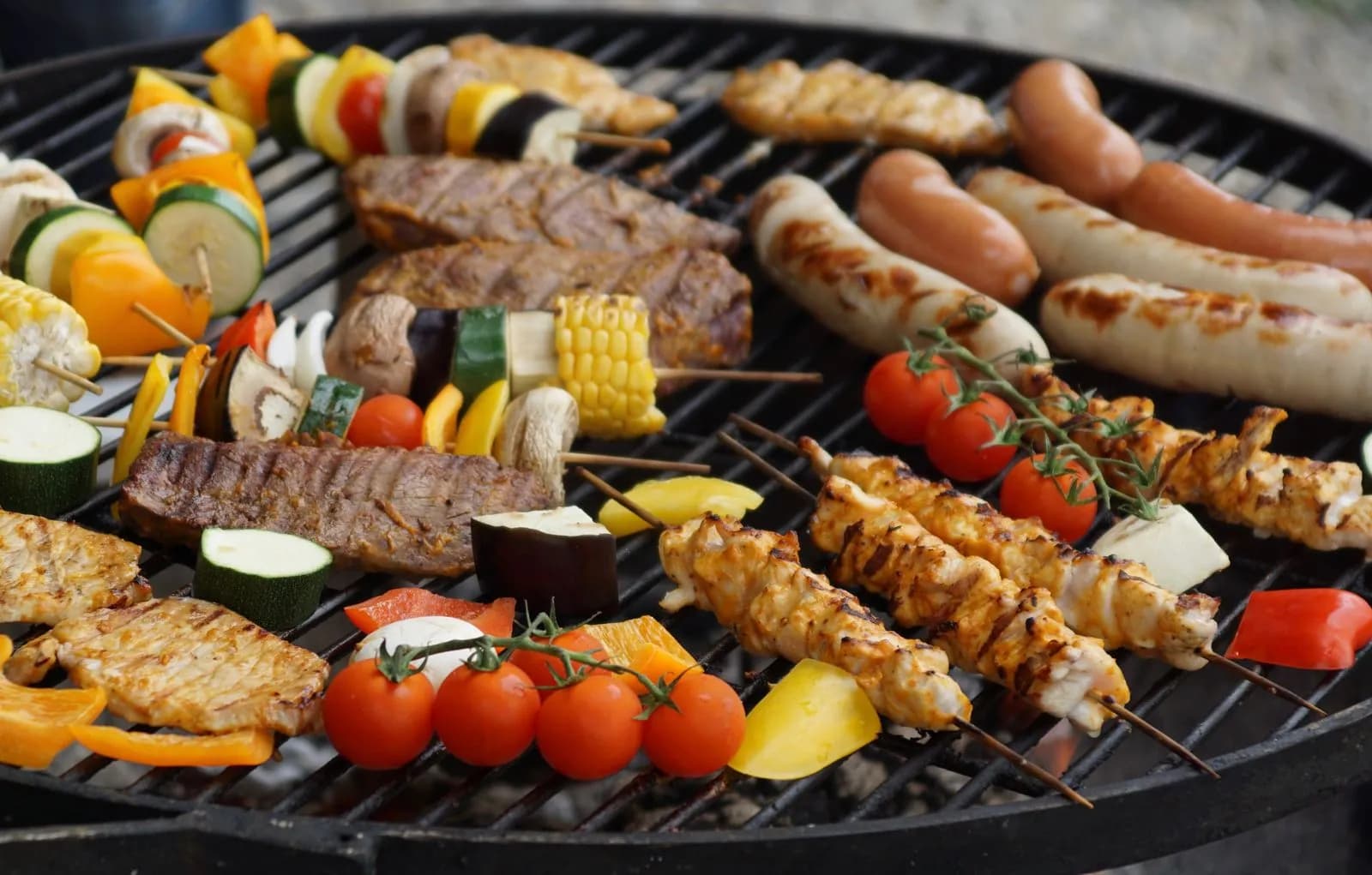 Parrillada surtida de carnes y verduras sobre una barbacoa