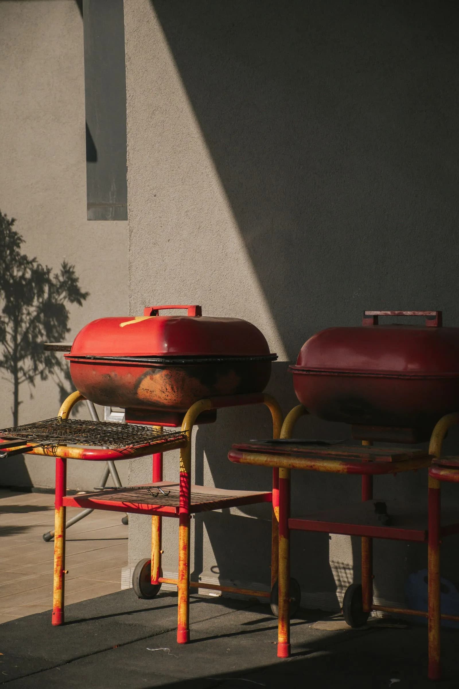 Dos barbacoas cerámicas en una terraza soleada, listas para elegir