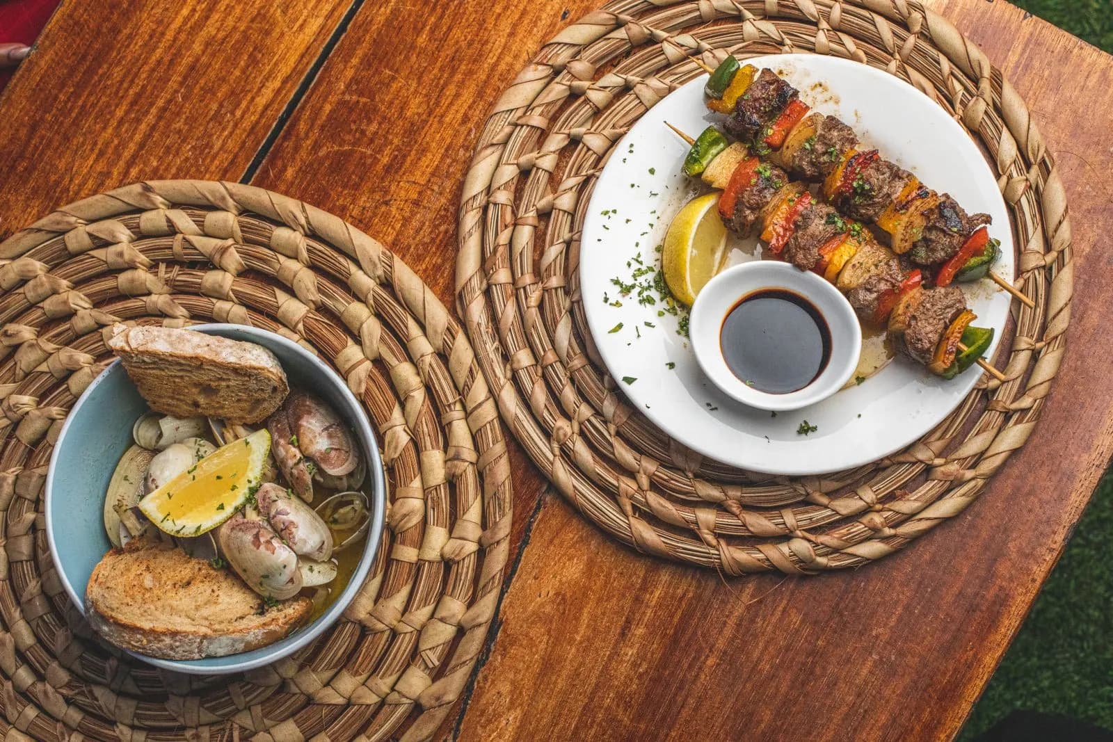 Mesa rústica con brochetas, patatas y guarniciones a la brasa, vista cenital