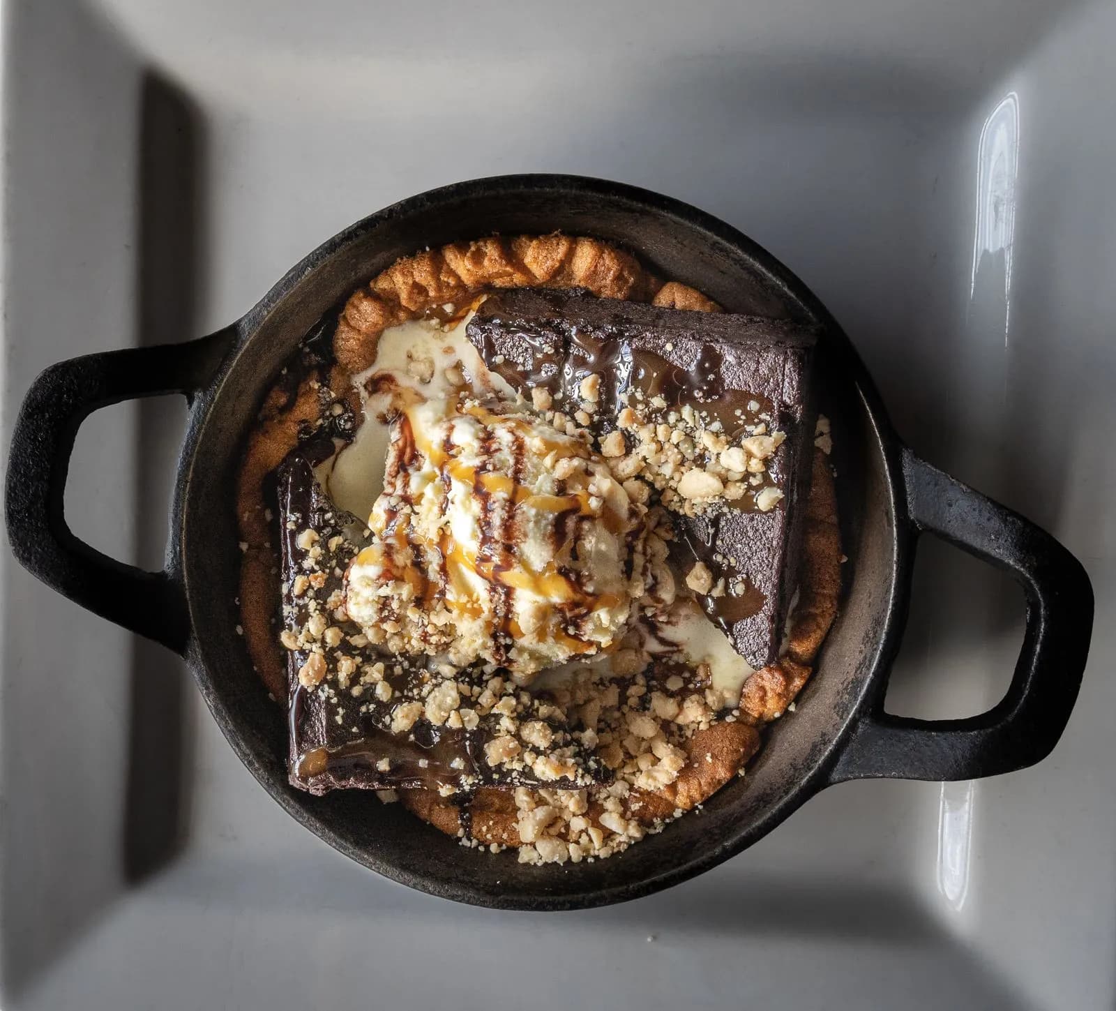 Brownie de chocolate en sartén de hierro con helado y caramelo