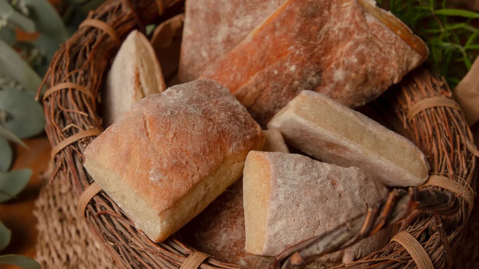 Dos chapatas de aceite de oliva recién horneadas sobre piedra, con corteza dorada crujiente y miga muy alveolada