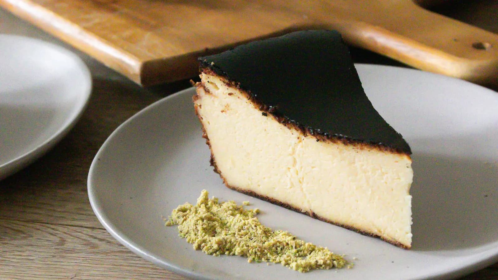 Porción de tarta de queso vasca quemada, superficie tostada y centro cremoso