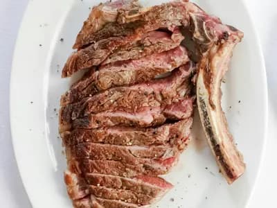 Chuletón a la parrilla recién salido del kamado, costra ennegrecida y carne rosada