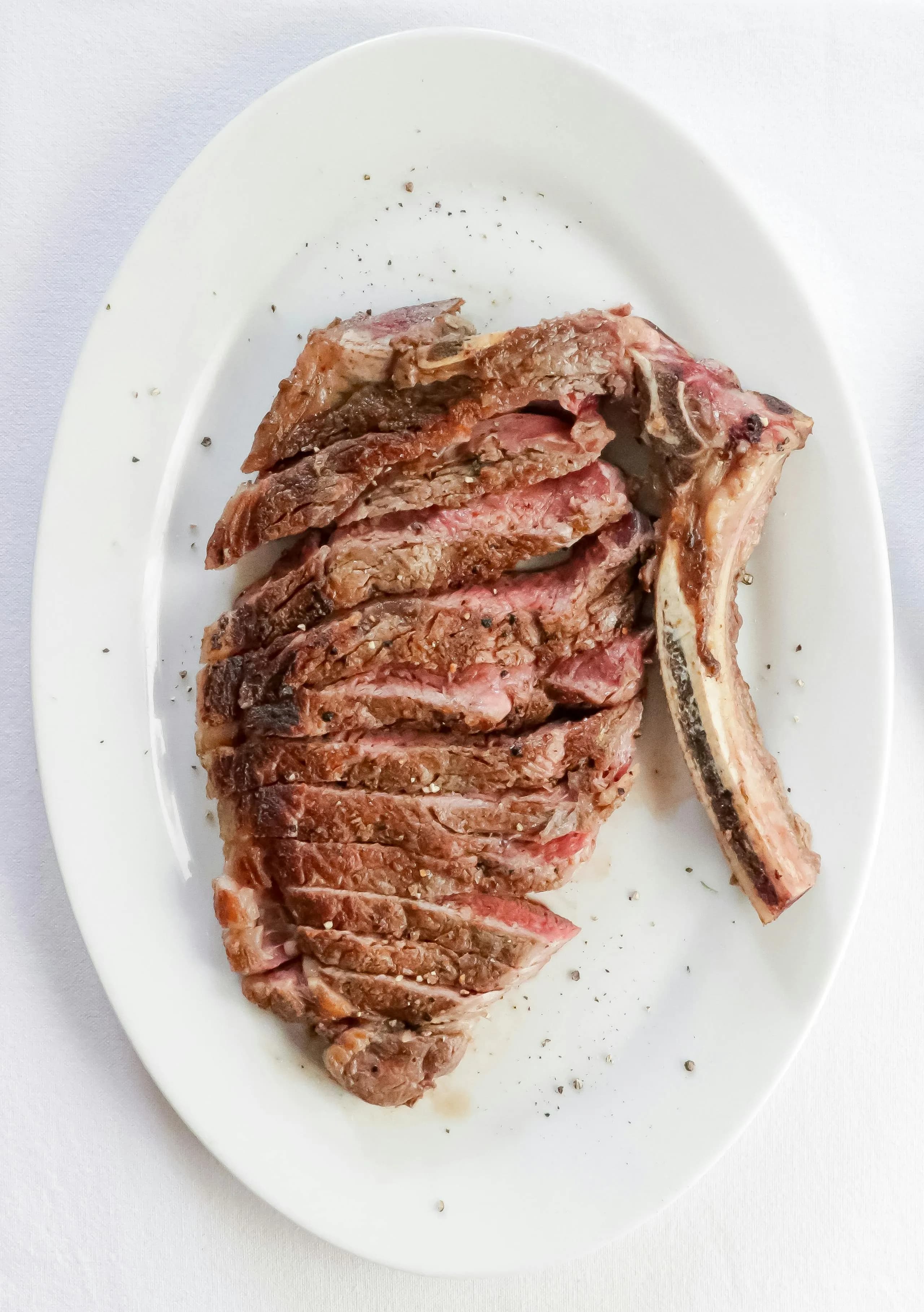 Chuletón a la parrilla recién salido del kamado, costra ennegrecida y carne rosada