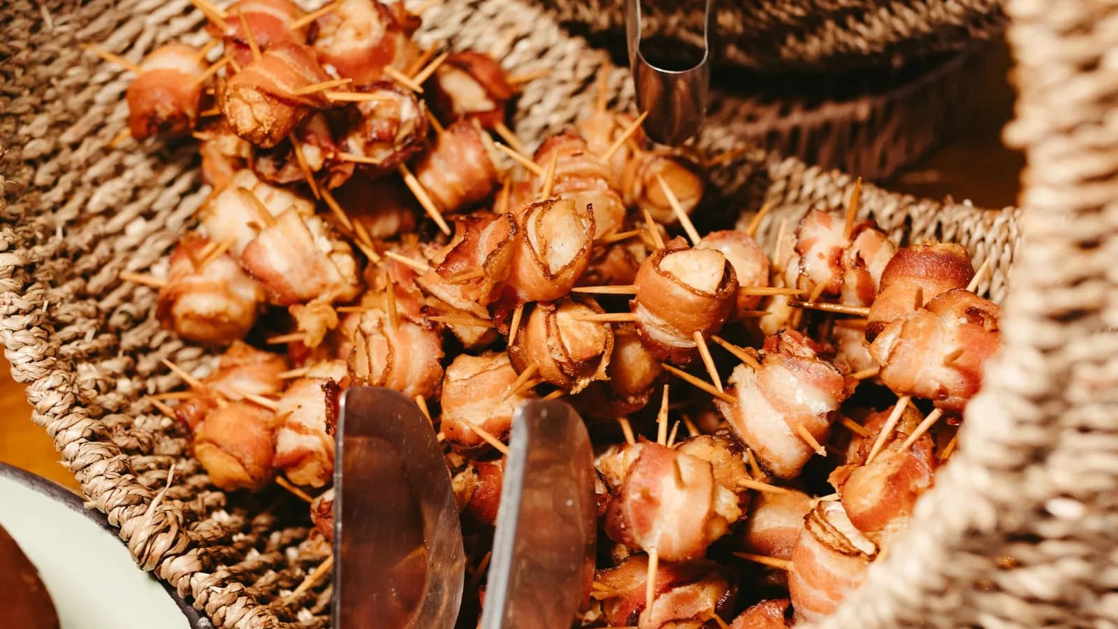 Dátiles Medjool envueltos en bacon caramelizado y glaseados con Pedro Ximénez, recién hechos sobre la parrilla de un kamado.