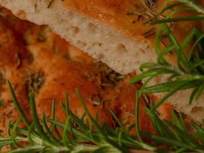 Focaccia con romero recién horneada, miga aireada y aceite de oliva
