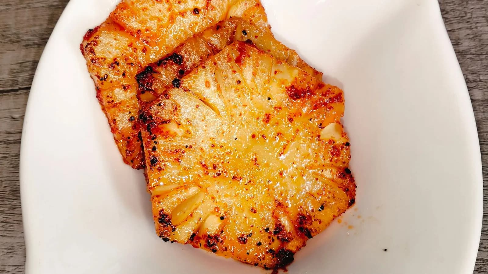 Rodajas de piña a la parrilla caramelizadas en un plato blanco