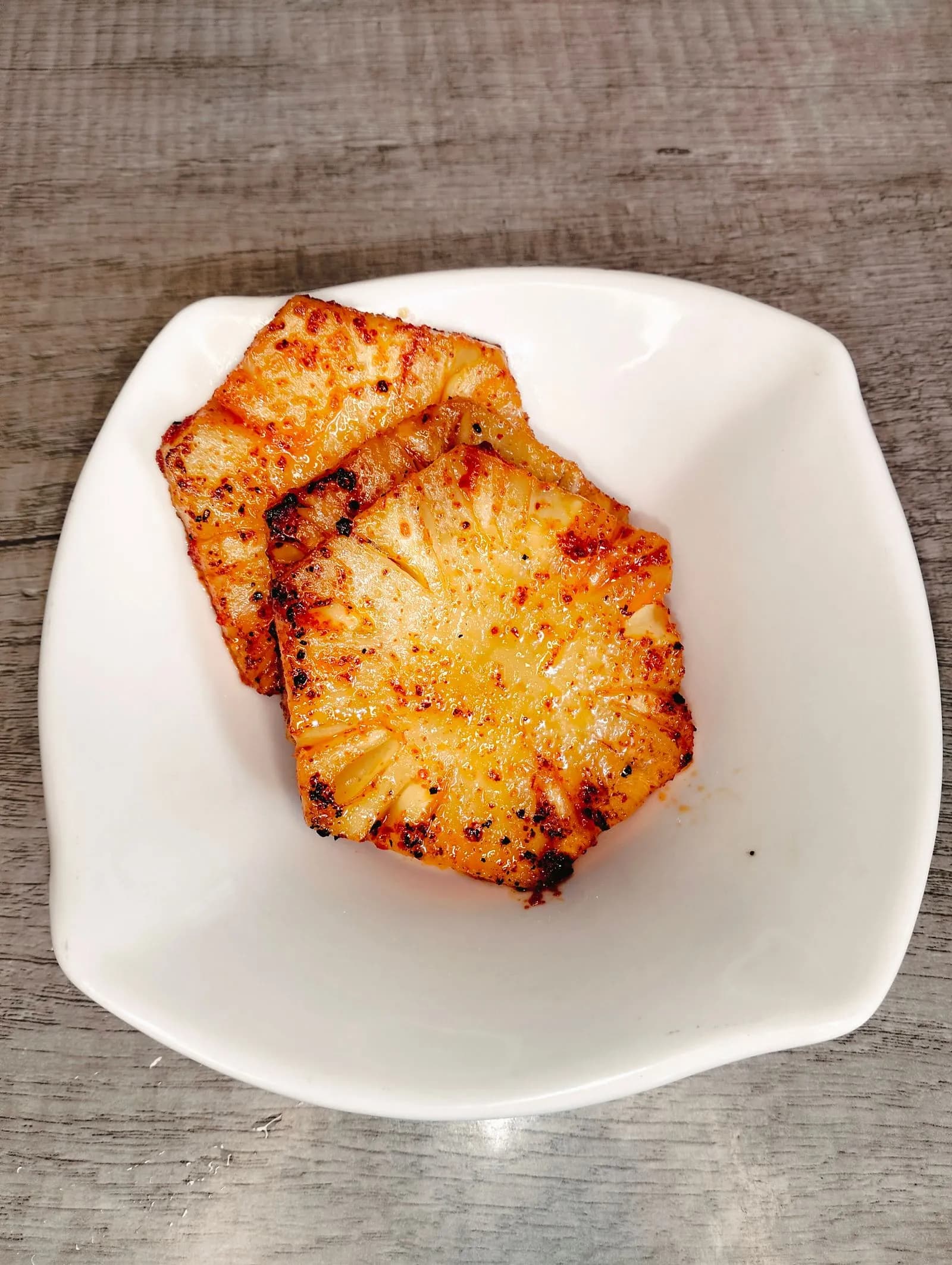 Rodajas de piña a la parrilla caramelizadas en un plato blanco