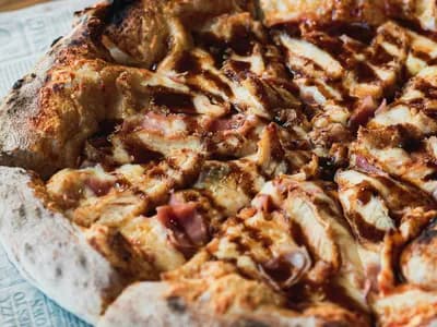 Pizza barbacoa de pollo ahumado con hilos de salsa BBQ y borde tostado