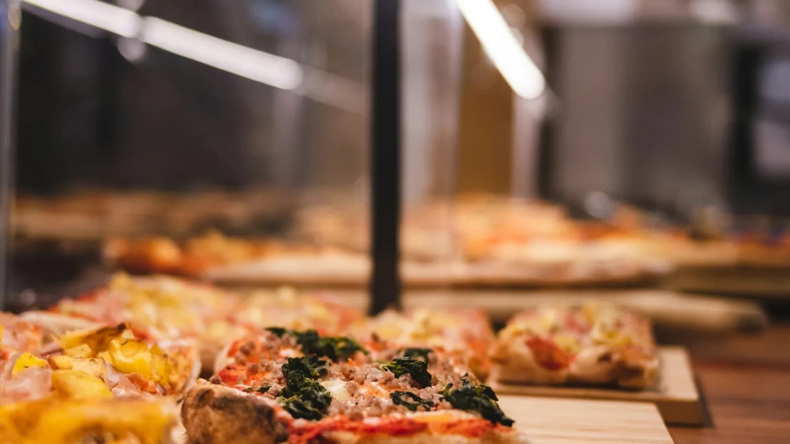 Porciones rectangulares de pizza romana al taglio sobre tablas de madera