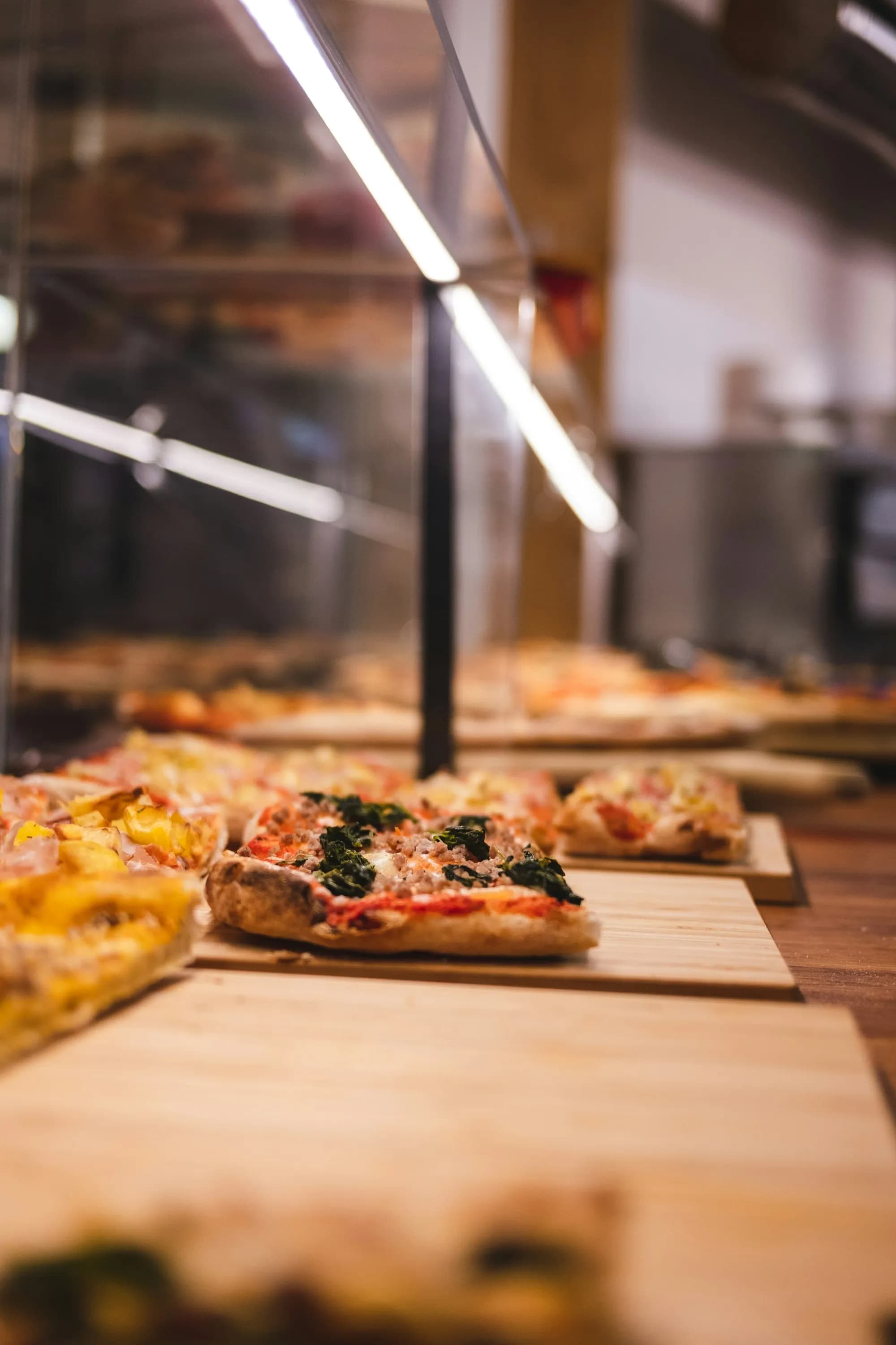 Porciones rectangulares de pizza romana al taglio sobre tablas de madera