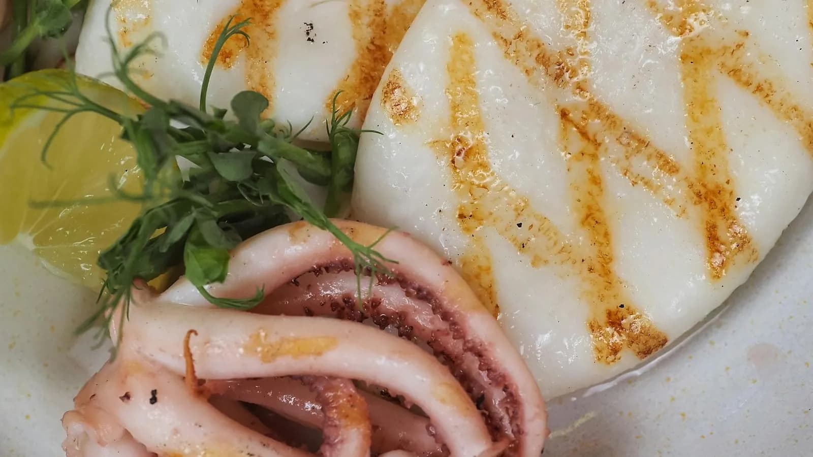 Sepia a la plancha con marcas de parrilla, limón y brotes
