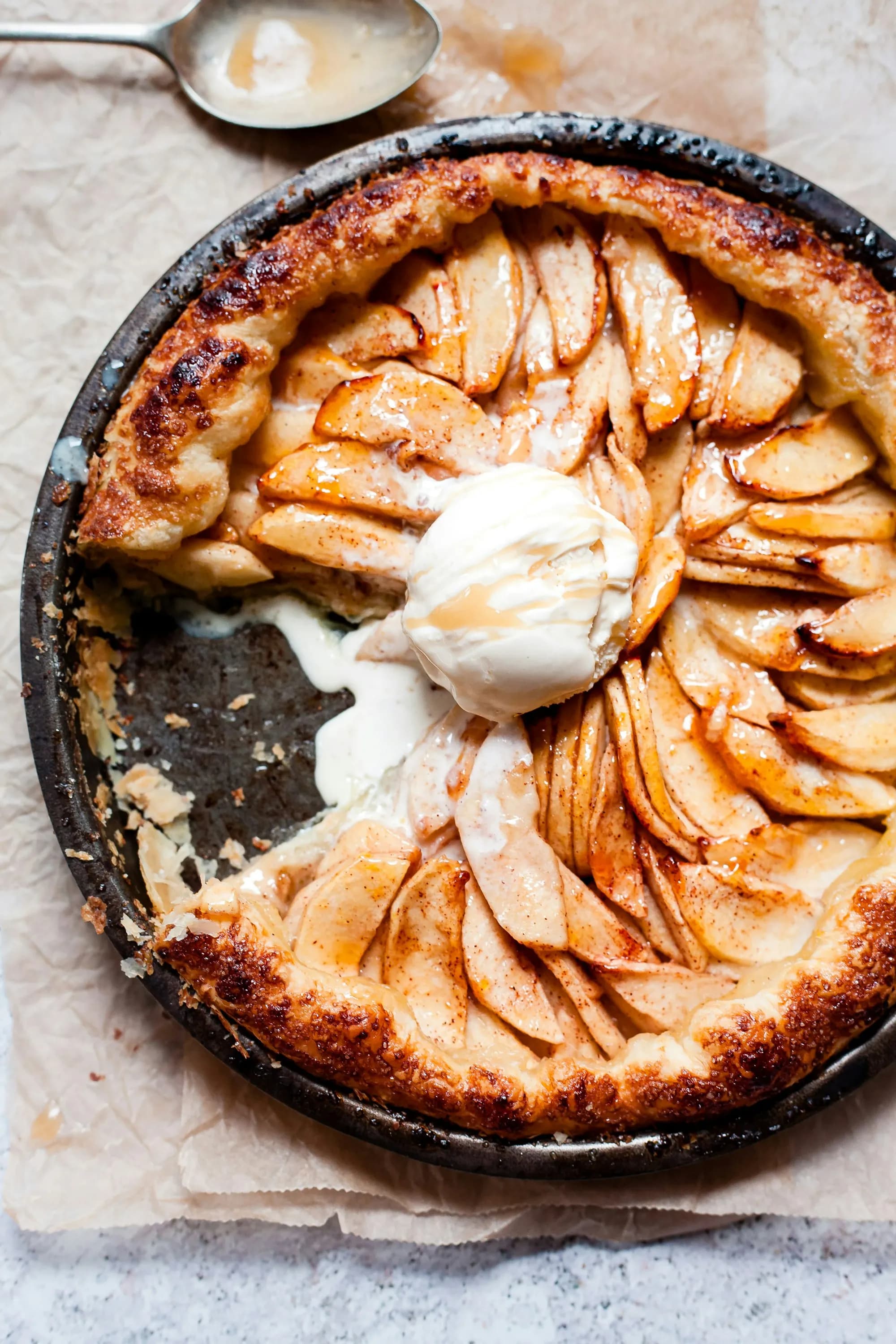 Tarta tatin de manzana caramelizada en molde de hierro, con bola de helado fundiéndose