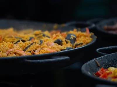 Arroz alicantino cocinándose en paellera sobre el fuego