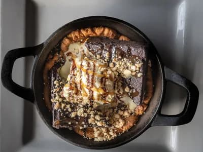 Brownie de chocolate en sartén de hierro con helado y caramelo