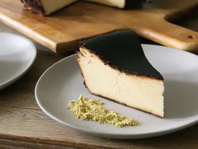 Porción de tarta de queso vasca quemada, superficie tostada y centro cremoso