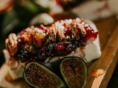Higos con queso, miel y nueces sobre tabla de madera