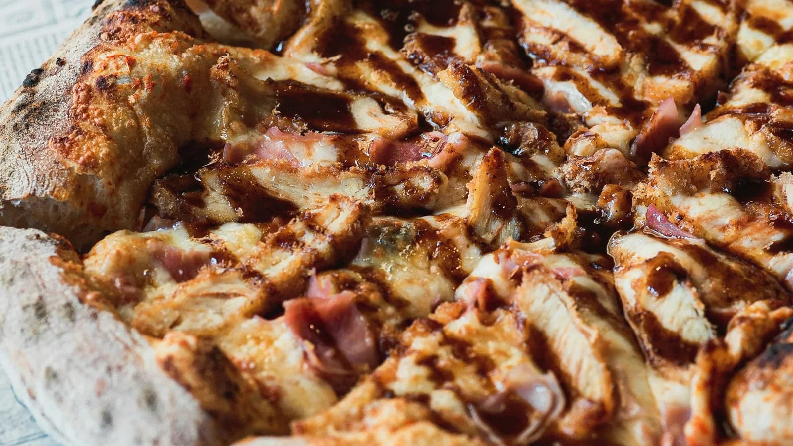 Pizza barbacoa de pollo ahumado con hilos de salsa BBQ y borde tostado