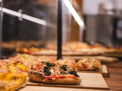 Porciones rectangulares de pizza romana al taglio sobre tablas de madera